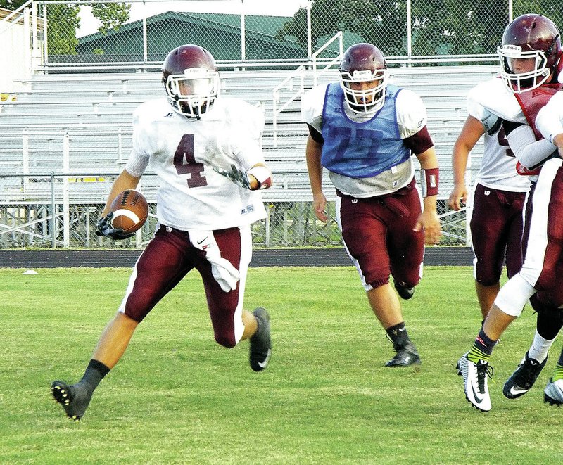 Photo by Randy Moll Gentry senior, Jake Faulkenberry, carries the ball during the scrimmage at the Meet the Pioneers event on Friday. Behind him, pursuing, is Dillon Stanley.