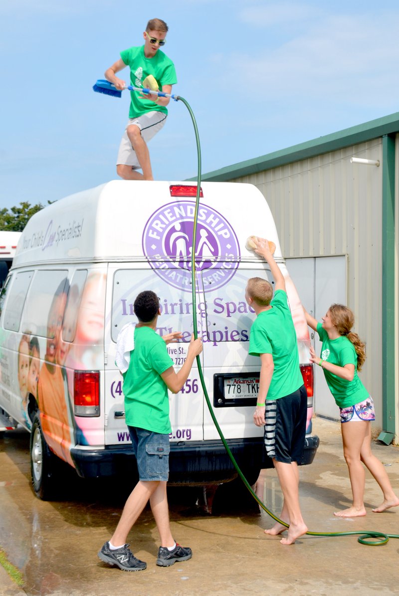 Janelle Jessen/Herald-Leader John Brown University students washed a van at Friendship Community Care on Monday morning.