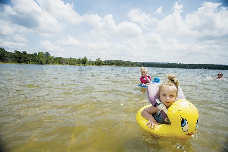 Greers Ferry Lake in north-central Arkansas has proven an attraction to area residents and far-away travelers for many summers. Here, Madison Bueltemann, foreground, and her sister Riley, then 2 and 3 years old, respectively, learn water safety while swimming in the shallows at Sandy Beach in Heber Springs during the summer of 2013. Now, business owners in the area are looking toward a water race in late September to get traffic coming to the area after the unofficial end of summer, Labor Day.