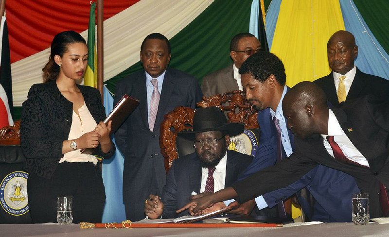 South Sudan President Salva Kiir signs a peace accord Wednesday in Juba aimed at ending two years of fighting with rebel forces. Standing behind Kiir to witness the signing are Kenyan President Uhuru Kenyatta (from center left), Ethiopian Prime Minister Hailemariam Desalegn and President Yoweri Museveni of Uganda.