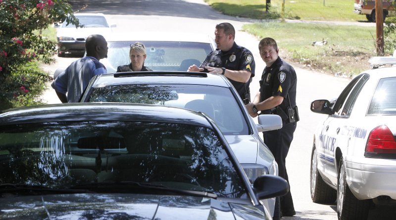 El Dorado Police Det. Tammie Goodwin, Sgt. Chris Lutman and Sgt. Trey Phillips, above, question a man about a shooting at a residence on Rock Island.