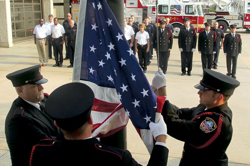 Honor Guard members John Hogue, Jason Fuller and Phillip Durham raise a ceremonial Patriot Day American flag in memory of those who lost their lives in the Sept. 11, 2001, attacks.