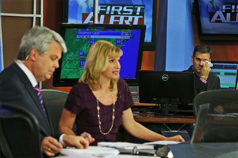 Meteorologist Leo Hirsbrunner wipes tears during the WDBJ-TV early morning newscast Thursday by Kimberly McBroom and Steve Grant in Roanoke, Va.