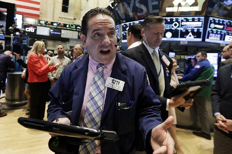 Trader Tommy Kalikas (front) works Thursday on the floor of the New York Stock Exchange. News about U.S. oil prices and the Chinese market Thursday bolstered Wall Street.