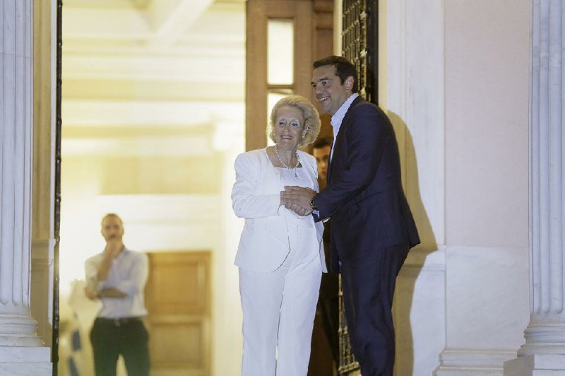 Alexis Tsipras poses in Athens, Greece, with new Prime Minister Vassiliki Thanou after Tsipras resigned as premier Thursday.