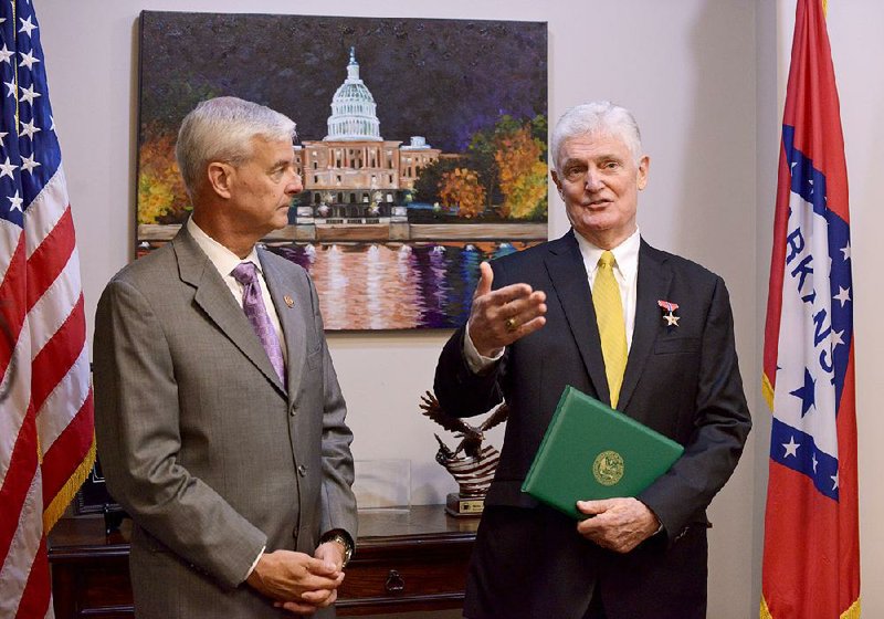Third District Rep. Steve Womack, R-Rogers, (left) and Bob Rodweller of Fayetteville talk to the media Friday at Womack’s office in Rogers after Rodweller was decorated with a Bronze Star. Rodwell was originally awarded the medal in 1969 while serving in the Army in Vietnam, but paperwork had been lost over the years.