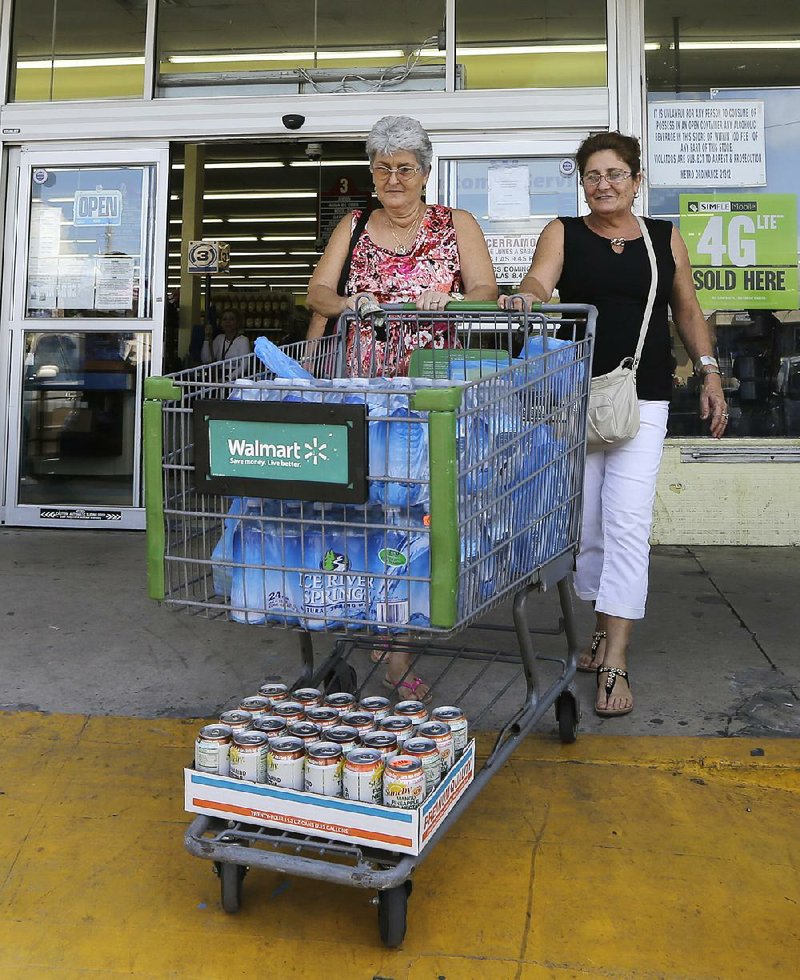 Mirna Gonzalez (left) and Mireya Rodriguez stock up as they prepare for Tropical Storm Erika at a Hialeah, Fla., supermarket Friday.