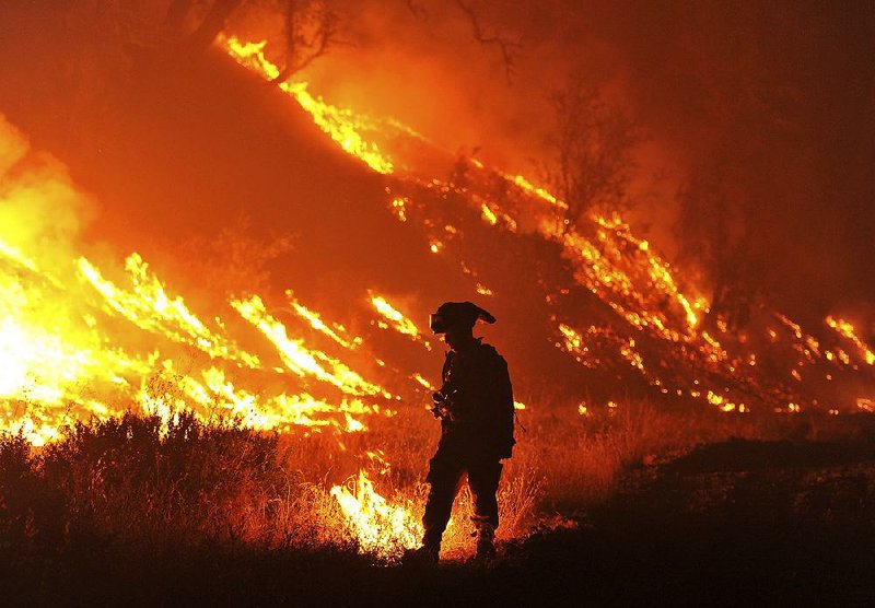 CalFire firefighter Bo Santiago lights a backfire earlier this month as the Rocky fire burns near Clearlake, Calif.