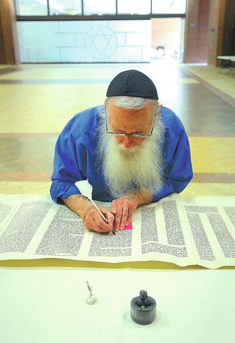 Rabbi Gedaliah Druin, a Sopher, or Jewish scribe from Miami, repairs text on a Torah Scroll at Temple B’Nai Israel in Little Rock. He will restore the ancient biblical text using the 3,000-year-old Jewish scribal craft and its 
instruments at Congregation Etz Chaim in Bentonville. A kickoff event is planned for Sunday.