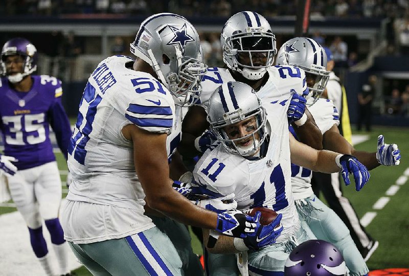 Dallas Cowboys wide receiver Cole Beasley (11) is congratulated by his teammates Saturday night during a 28-14 loss to the Minnesota Vikings in Arlington, Texas.