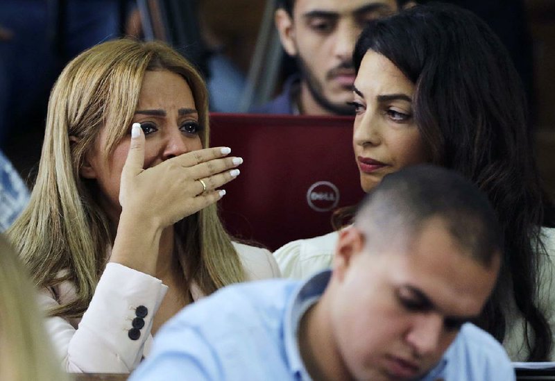 Marwa Fahmy, wife of Canadian Al-Jazeera journalist Mohammed Fahmy, bursts into tears Saturday after her husband and two other journalists were sentenced in Cairo to three years in prison on charges of “spreading false news.” Human-rights lawyer Amal Clooney sits beside Marwa Fahmy.