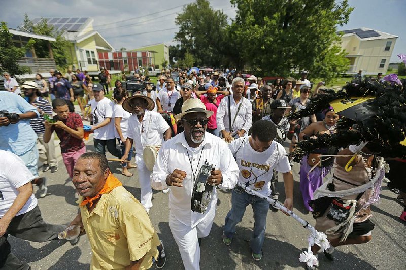 A second-line parade Saturday to commemorate the 10th anniversary of Hurricane Katrina moves past homes built by actor Brad Pitt’s Make It Right Foundation in the Lower Ninth Ward in New Orleans.