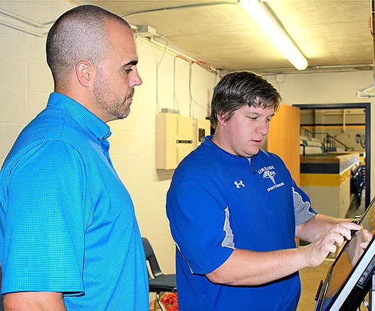 Submitted photo Clint Crabtree, left, director of Physical Therapy at Levi Hospital, stopped by the Lakeside Campus Aug. 20 to check out the Sports Medicine department. The department has added a new Thumb Scanning Documenting System by Vivature. Athletic trainer T.J. White, right, said the system will allow Lakeside to document injuries faster.