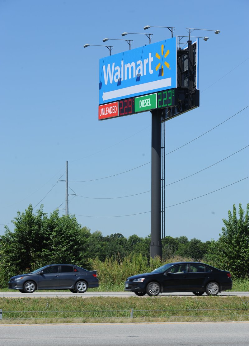 Traffic passes a sign for the Walmart Supercenter on Elm Springs Road in Springdale. Of the four largest cities in Northwest Arkansas, Springdale has the greatest maximum allowance for height and square footage of sign faces.