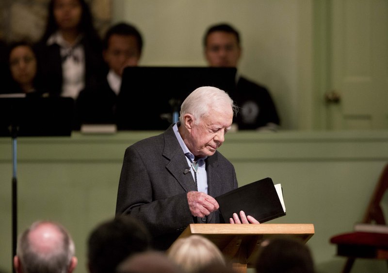 Former President Jimmy Carter opens up a Bible while teaching Sunday School at Maranatha Baptist Church in Plains, Ga., in this Aug. 23 file photo.