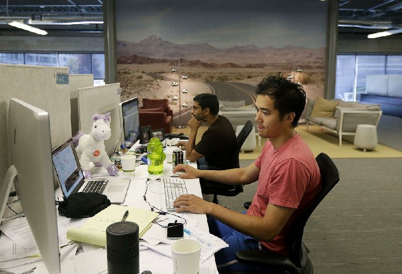 MetroMile employees Allen Tran and Muhammad Waliji work at their desks in a San Francisco office earlier this month. The company sells auto insurance on a per-mile basis.