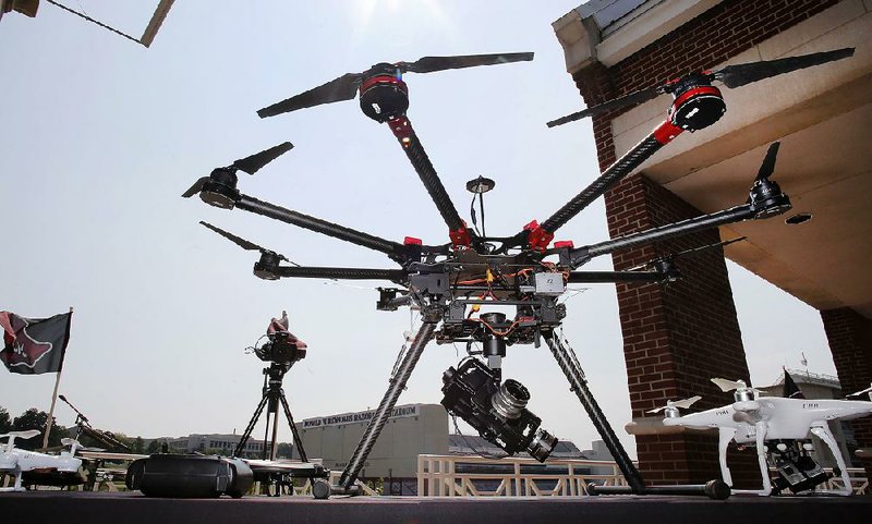 A variety of drones is displayed on the terrace of Janelle Y. Hembree Alumni House on the campus of the University of Arkansas in Fayetteville on Monday as officials announce a policy on the unmanned aircraft systems.