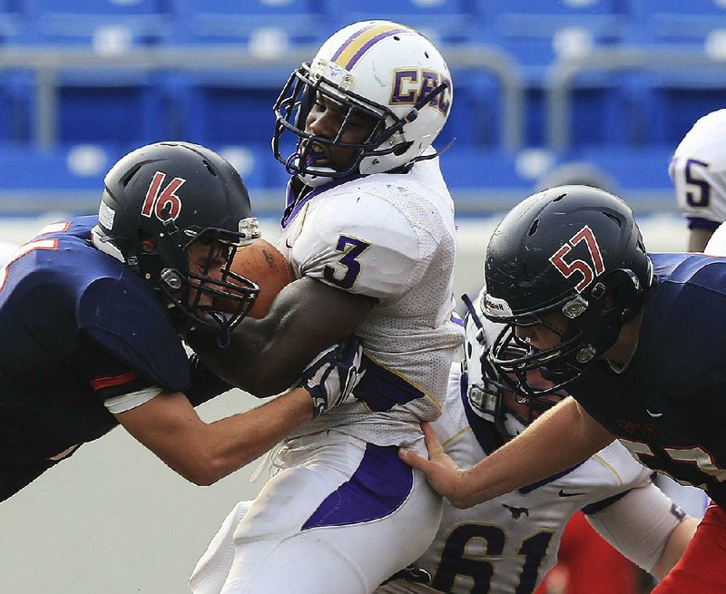 Central Arkansas Christian running back Braylon Harris (3) tries to get through Arkansas Baptist defenders Thomas Lewis (16) and Harrison Ward (57) on Tuesday night at War Memorial Stadium in Little Rock. Harris rushed 12 times for 133 yards in the Mustangs’ 34-6 victory. More photos available at arkansasonline.com/galleries.