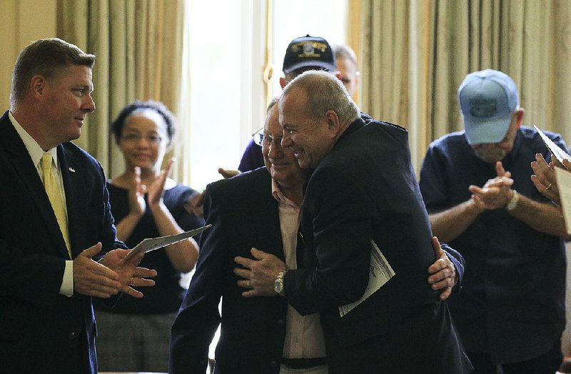 U.S. Rep. Rick Crawford (left) and state Rep. Mike Holcomb of Pine Bluff (right) congratulate James Smith of Star City (center, right) after Smith received a Silver Star at the state Capitol on Tuesday, decades after his service in Vietnam. 