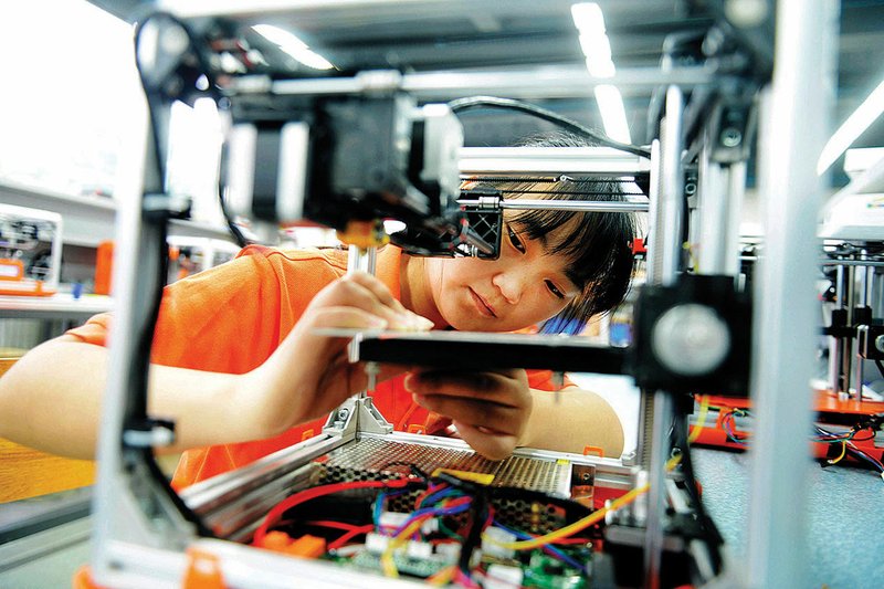 A worker assembles a 3-D printer Tuesday in a factory in Qingdao in eastern China’s Shandong province. Chinese manufacturing showed continuing signs of weakness in August, government reports said Tuesday.