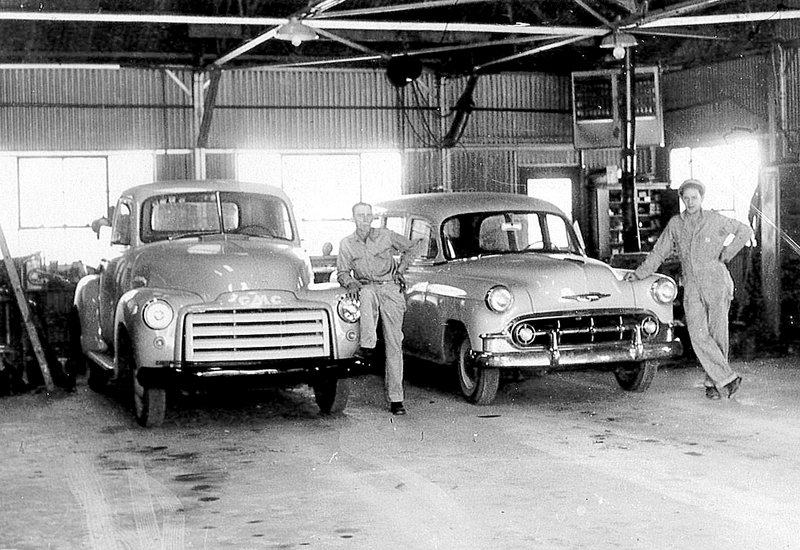 Photo submitted Harley McKinney and a transportation department employee stood next to the school&#8217;s two maintenance deparment vehicles in the 1950s.