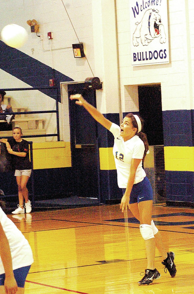 Photo by Mike Eckels Decatur&#8217;s Celine Prelle (#12) serves the volleyball to Lincoln during the third set of the Decatur-Lincoln volleyball game at Peterson Gym in Decatur on Aug. 25. The Bulldogs won their first-ever game since beginning the program in January. The Bulldogs defeated the Wolves, 3 sets to 2.
