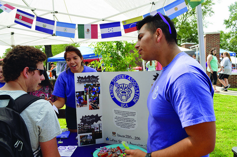 University of Central Arkansas junior Ryan Johnston, left, of Poteau, Okla., talks with juniors Paulina Jimenez, center, of North Little Rock and Javier Hernandez of Springdale, both members of the Latino Student Organization. The group had a booth at Conway Daze, held Friday on campus for businesses and campus clubs, organizations and departments to get the word out about what they offer.