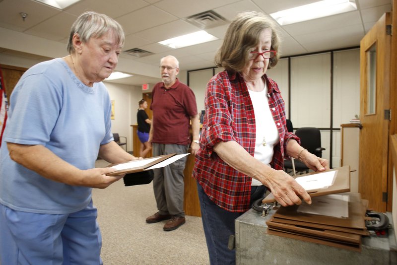 Judy Beavers (from right), Mort Gitelman and MacZeatta Ramsey cast their ballots Tuesday on the first day of early voting on the proposed Fayetteville Uniform Civil Rights Protection ordinance at the Washington County Clerk and Probate office in the County Courthouse in Fayetteville. Early voting continues today, Thursday and Friday and then again from 7:30 a.m. to 7:30 p.m. Sept. 8.