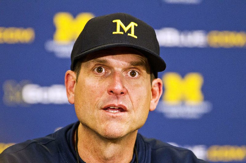 In this April 4, 2015, file photo, Michigan head coach Jim Harbaugh answers questions during a press conference after their spring NCAA college football game in Ann Arbor, Mich. 