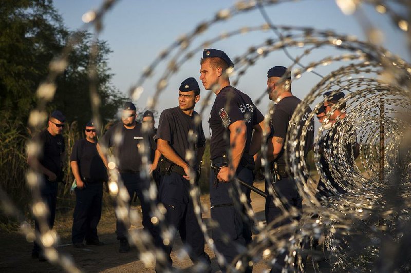 Police stand guard Wednesday near to the Hungarian town of Roszke at the border with Serbia.