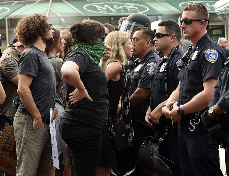 Baltimore police block protesters Wednesday as activist Kwame Rose is detained in the purported assault of an officer during a rally outside the city courthouse. A judge Wednesday refused to dismiss charges against six police officers in the death of 25-year-old Freddie Gray, a black man who was fatally injured while in police custody.  