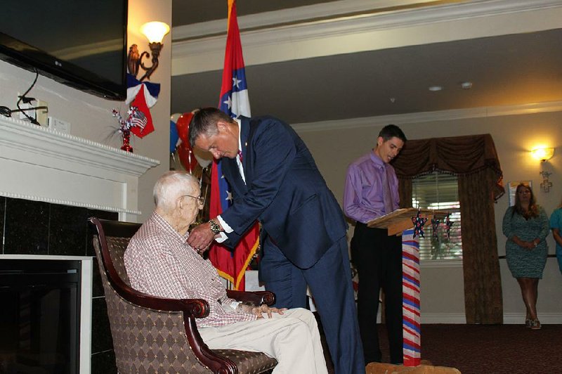 U.S. Rep. Bruce Westerman pins service medals to the shirt of World War II veteran Cordy A. Ramer Jr. during a ceremony in Rison on Wednesday. 