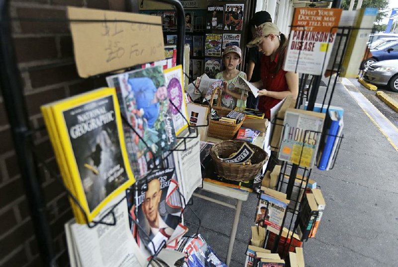 Children browse Wednesday at Lakeside News, one of the last newsstands in metro New Orleans. 
