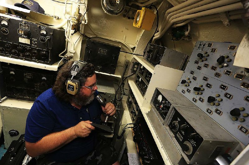 Navy veteran John Moore, who served from 1980 to 1986 on the submarine USS Ohio, mans the radio on the USS Razorback submarine Wednesday in North Little Rock. He was contacting other radio operators to tell them about the Razorback’s World War II history on the 70th anniversary of the surrender of Japan. 