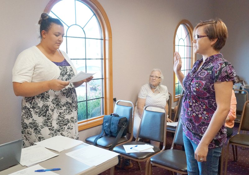 RITA GREENE MCDONALD COUNTY PRESS Left to right: Melissa Ziemianin, city clerk, Pineville, swearing in Amanda Crawford as the new tax collector at the Pineville city council meeting Aug. 25.
