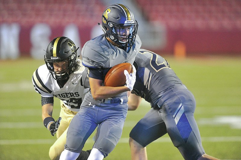 Shiloh Christian receiver Tyler Roth tries to shake Charleston defender Colton McDonald as he runs for a gain Tuesday at Razorback Stadium in Fayetteville.