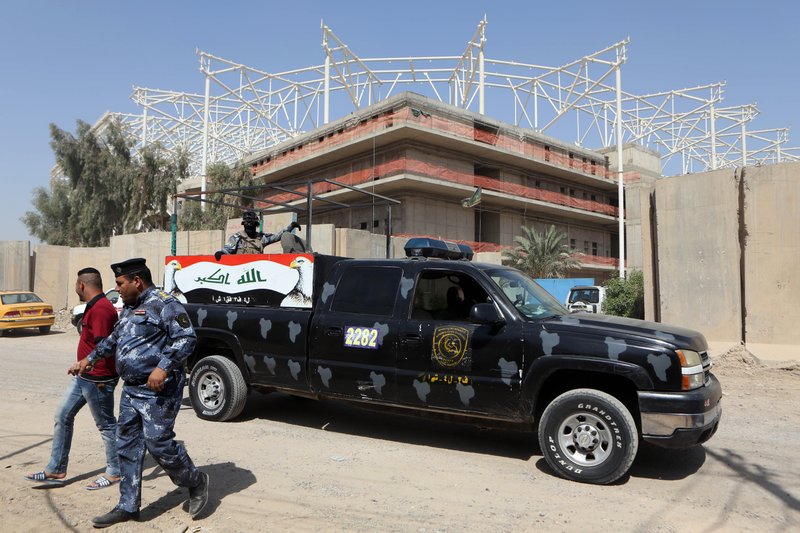 Iraqi security forces guard the entrance to a sports complex being built by a Turkish construction company, in the Shiite district of Sadr City, Baghdad, Iraq, Wednesday, Sept. 2, 2015. Masked men in military uniforms kidnapped 18 Turkish workers and engineers working at the site in Baghdad at dawn Wednesday, bundling them into several SUVs and speeding away.