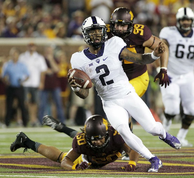 TCU quarterback Trevone Boykin (2) avoids the tackle of Minnesota linebacker Jack Lynn (50) and defensive end Andrew Stelter (99) during Thursday’s game at TCF Bank Stadium in Minneapolis. Boykin completed 26 of 42 passes for 246 yards and 1 touchdown while rushing for 92 yards on 18 carries, including a 19-yard score, to help the Horned Frogs hold off a late fourth-quarter rally by the Golden Gophers, who are the only team in the nation scheduled to face The Associated Press’ current No. 1 and No. 2 teams this season. Minnesota will play top-ranked Ohio State on Nov. 6.