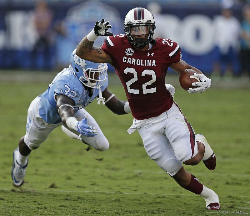 South Carolina running back Brandon Wilds (22) runs past North Carolina linebacker Joe Jackson in the first half of the Gamecocks’ come-frombehind victory over their border rivals Thursday at Bank of America Stadium in Charlotte, N.C.