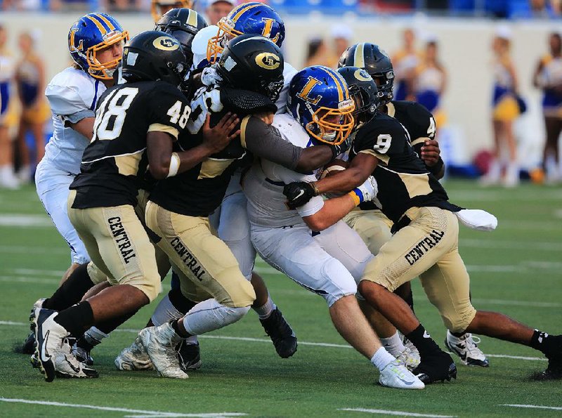 Hot Springs Lakeside running back Colt Housley (second from right) is tackled by a host of Little Rock Central defenders during Thursday’s game at War Memorial Stadium in Little Rock. Central led 42-30 with 2:33 remaining, but a late charge by the Rams resulted in a 44-42 Lakeside victory.