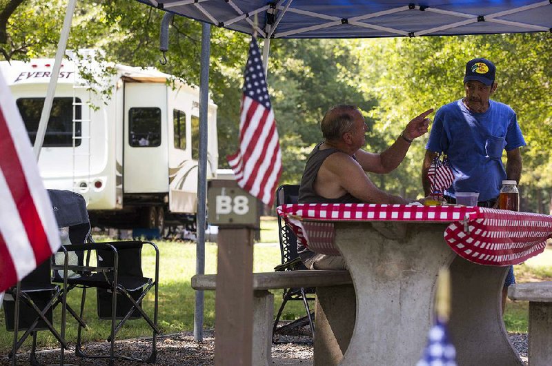 Doug Crowder (left) of Little Rock and Danny Crowder of Cabot relax Thursday at Maumelle Campground and Recreation Area. The Crowders were setting up camp for the Labor Day weekend. Other cousins and friends were expected to join them, setting up at adjacent campsites.