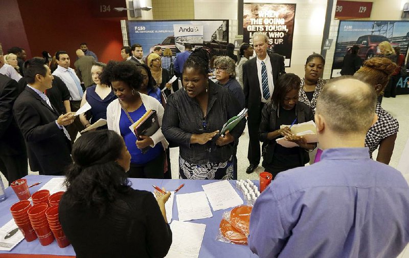 Job seekers visit with prospective employers this summer at a job fair in Sunrise, Fla. The number of unemployment claims indicates that there aren’t a lot of people leaving their jobs involuntarily, one economist says. 