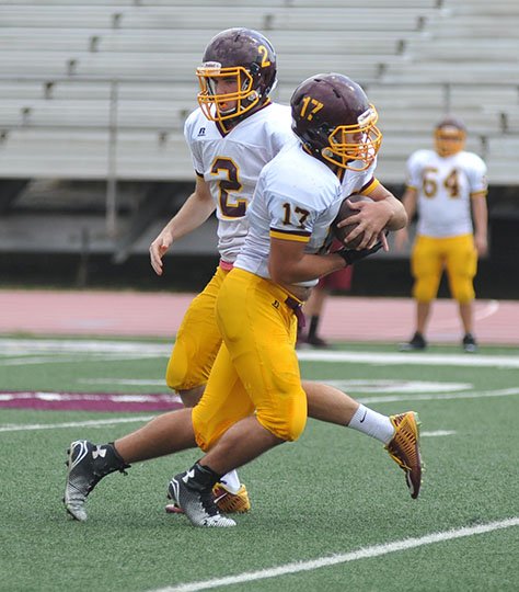 The Sentinel-Record/Mara Kuhn PRACTICE RUN: Lake Hamilton senior quarterback Nash Teague (2) hands off to sophomore Randall Nichols during practice on Wednesday. Teague is expected to split time with classmate Bryce Briggs against Hot Springs in a season-opener tonight at Wolf Stadium.
