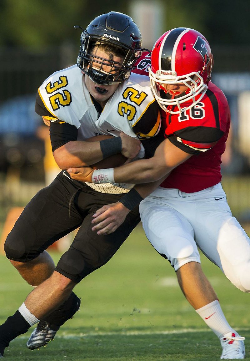 Prairie Grove fullback Reed Orr (32) is stopped by Farmington’s Caleb Williams on Friday during the teams’ season opener. Farmington jumped out to a three-touchdown lead and got a big night from Trenton McChristian in a 28-12 victory.