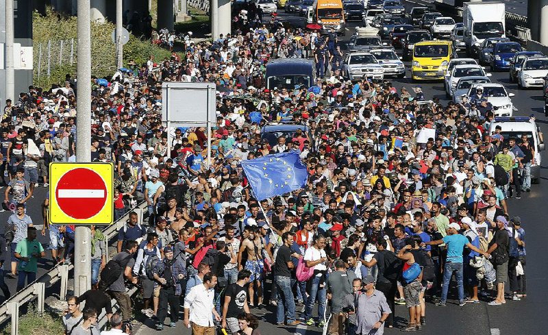 Hundreds of migrants walk out of Budapest, Hungary, on Friday, snarling traffic as they try to make their way to the Austrian border 106 miles away. By nightfall, they had covered about 30 miles. 