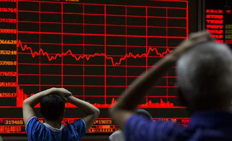 Investors keep watch on a display of the Shanghai Composite Index at a brokerage in Beijing. 