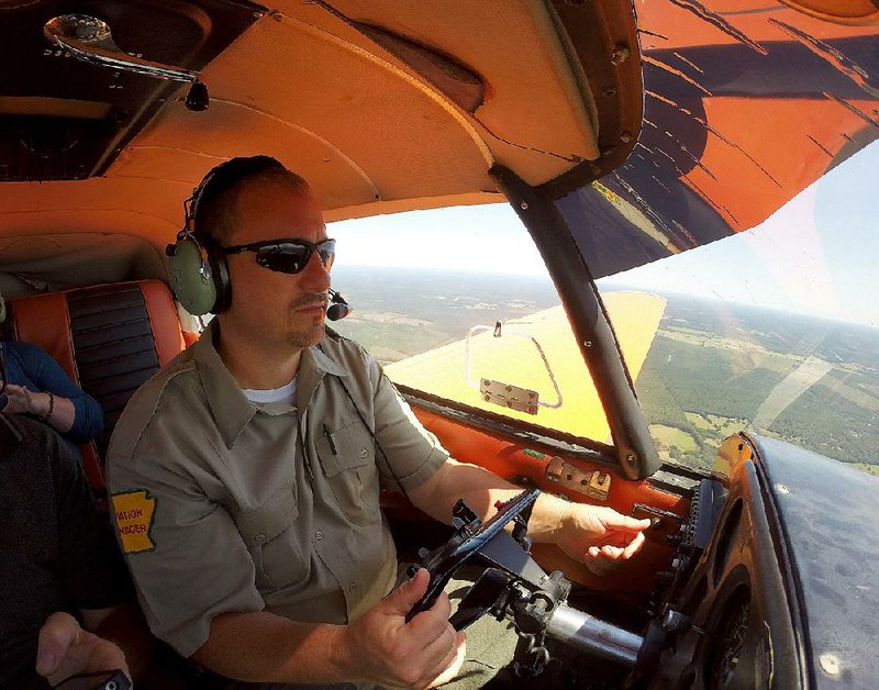 Arkansas Forestry Commission Aviation Manager Michael Sellers watches for fires and signs of timber damage or disease during a flight near Malvern in late August.