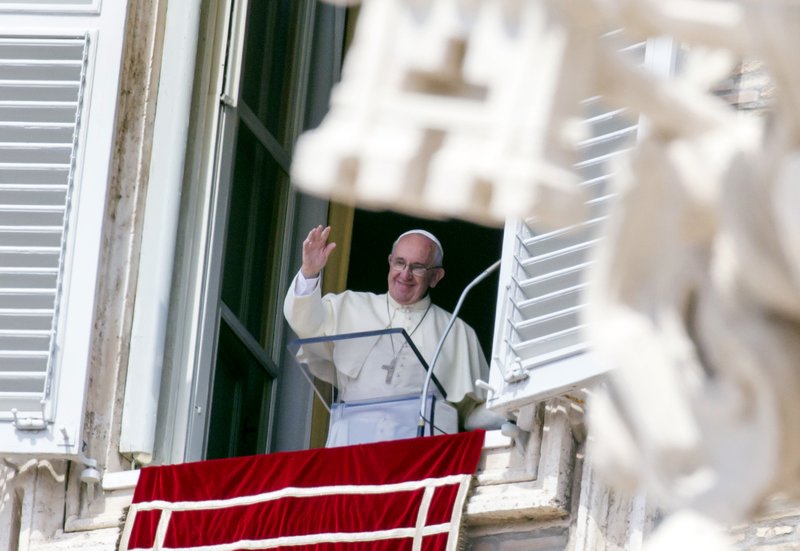 Pope Francis waves to faithful as he arrives to recite the Angelus noon prayer from his studio window overlooking St. Peter's Square at the Vatican, Sunday, Sept. 6, 2015. The Vatican will shelter two families of refugees "who are fleeing death" from war or hunger, Pope Francis announced Sunday as he called on Catholic parishes, convents and monasteries across Europe to do the same. 