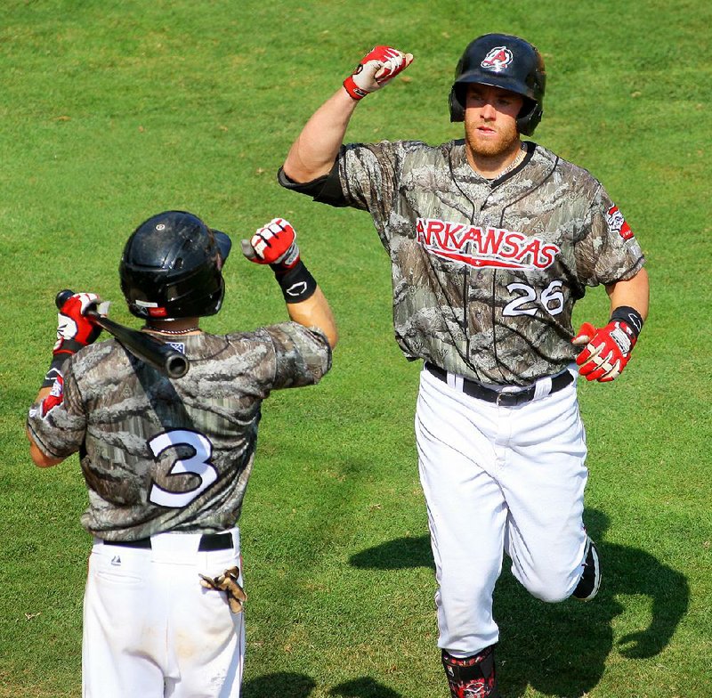 Arkansas right fielder Cal Towey (right) is greeted at home plate by teammate Blake Gailen after his home run in the fifth inning helped give the Travelers a 3-1 victory over Northwest Arkansas on Sunday at Dickey-Stephens Park in North Little Rock.