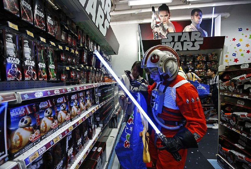 A fan dressed as a Star Wars character shops at a toy store at midnight in Hong Kong as part of the global event called Force Friday to reveal new Star Wars toys and other merchandise connected to Star Wars: Episode VII-The Force Awakens, which will premiere in December.